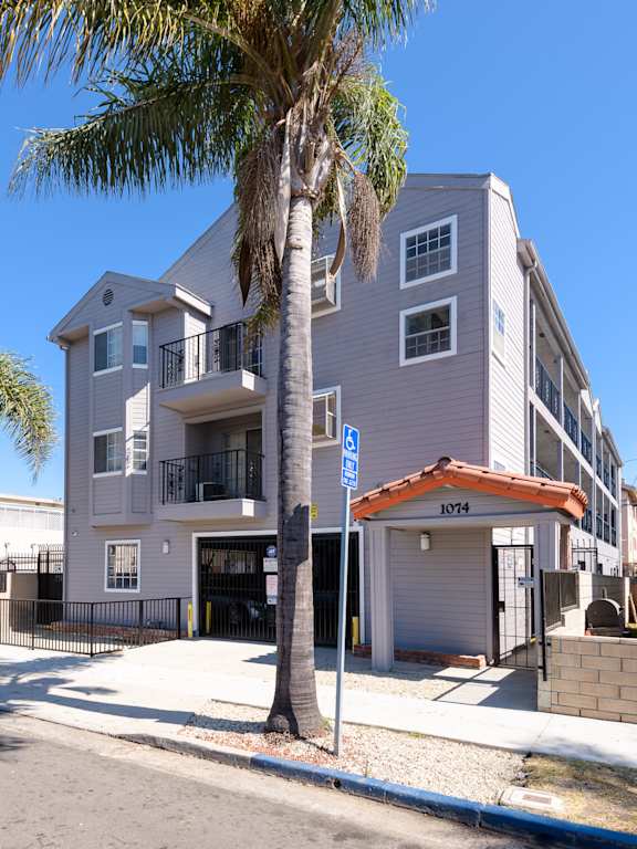 Floor Plan  A palm tree stands in front of a two-story building with a garage.