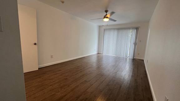 A room with wooden floors and a ceiling fan.