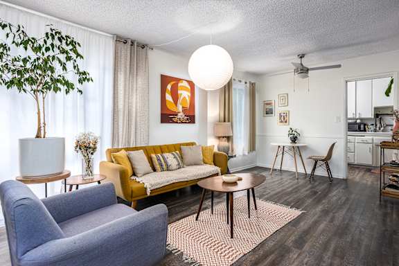 a living room with a yellow couch and a table