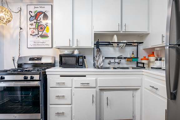 a kitchen with white cabinets and a stove and a sink