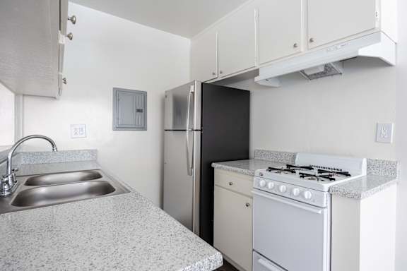 an empty kitchen with a stove refrigerator and sink