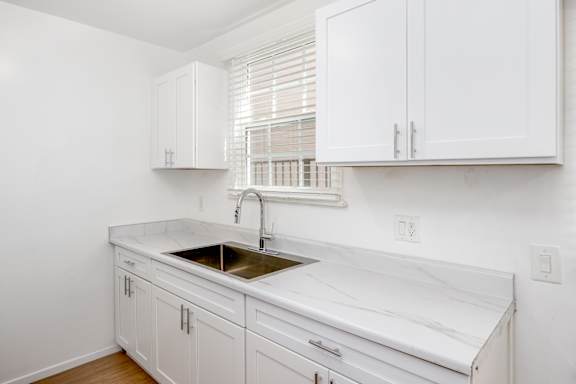 a kitchen with white cabinets and a sink