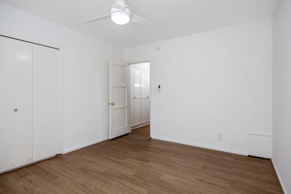 an empty living room with white walls and a wood floor