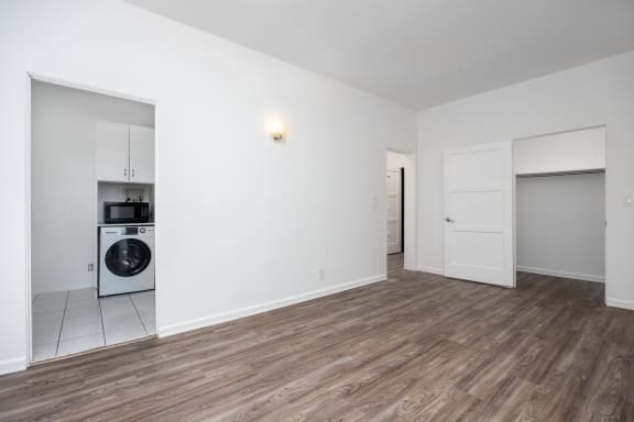 a living room with a washer and dryer in it and a laundry room