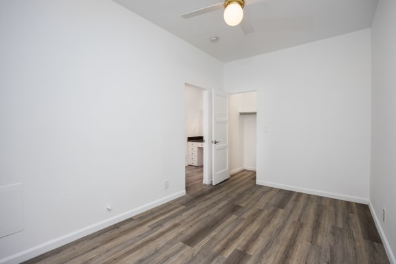 an empty living room with white walls and wood flooring