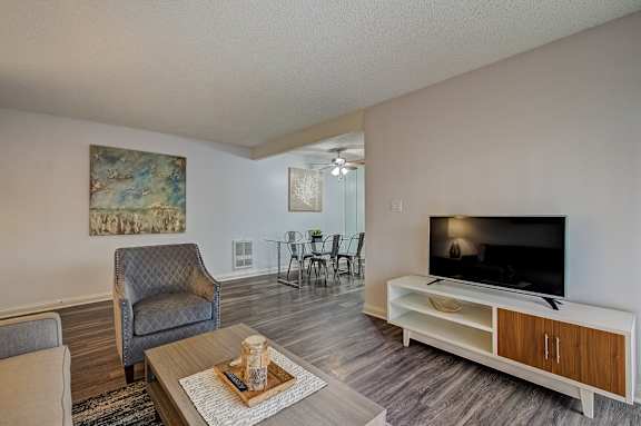 a living room with a flat screen tv and a table with chairs