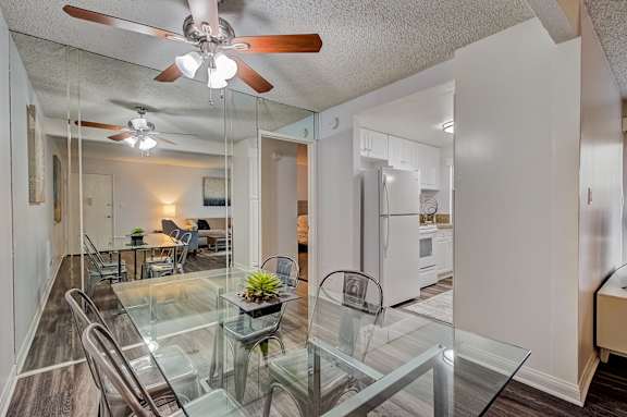 the living room and dining room with a glass table and chairs