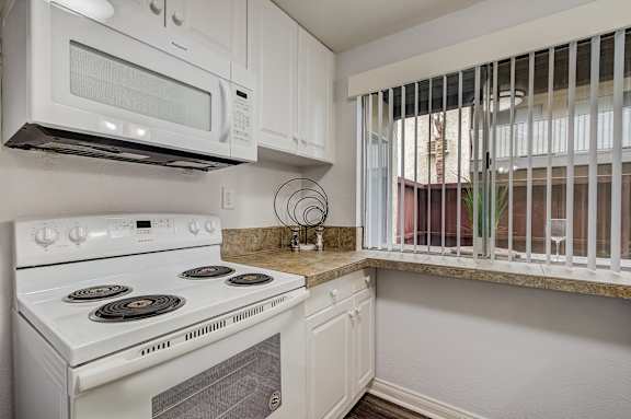 a kitchen with white appliances and a window