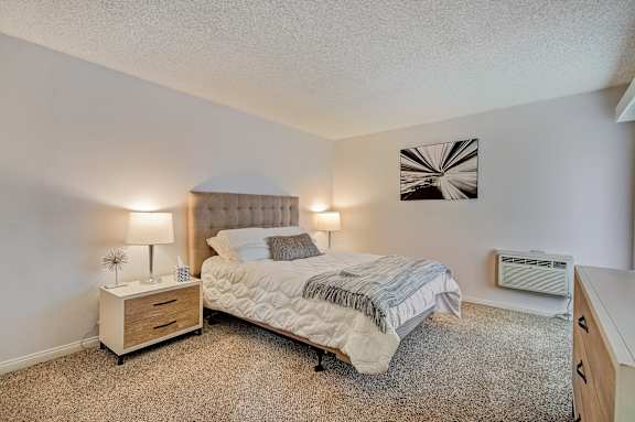 a bedroom with a bed and a dresser and a window