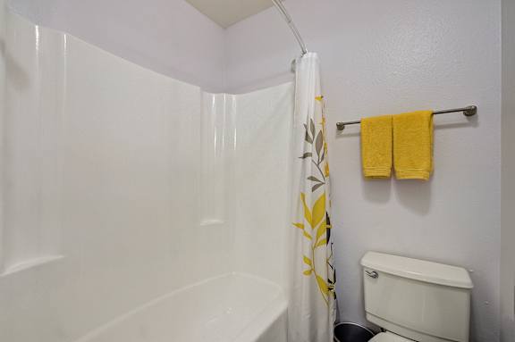 the bathroom has a shower and a toilet in it