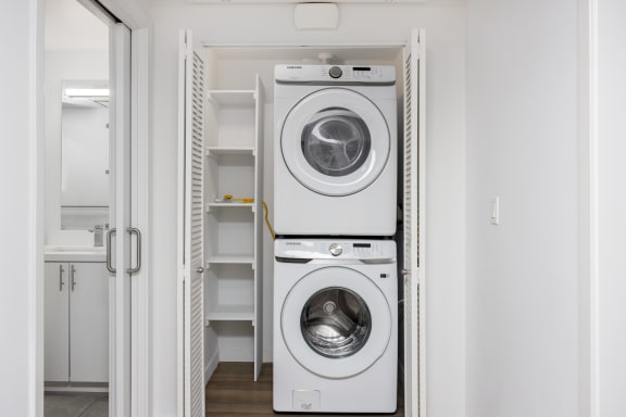 a white washer and dryer in a white laundry room