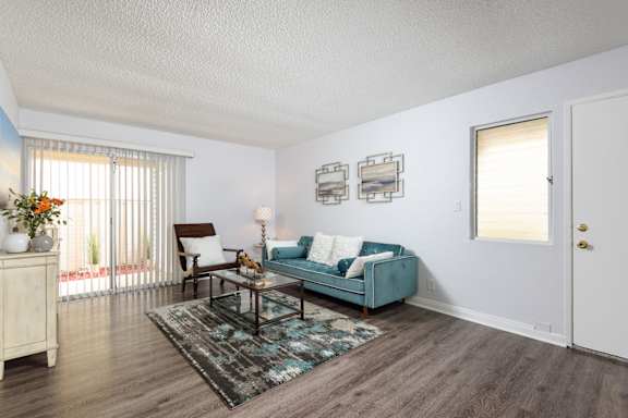 the living room of an apartment with a blue couch and a coffee table