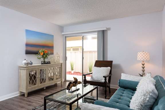 a living room with a blue couch and a glass table