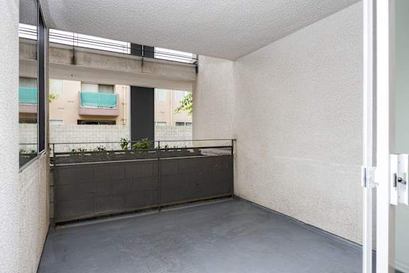 an empty room with a balcony and a window