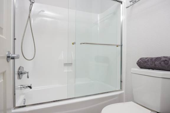 a white bathroom with a shower and a toilet