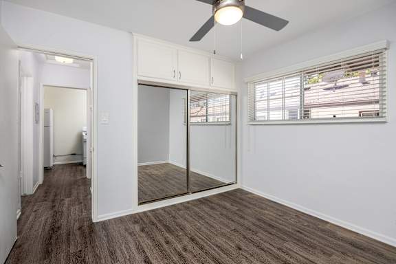 an empty room with a window and a ceiling fan