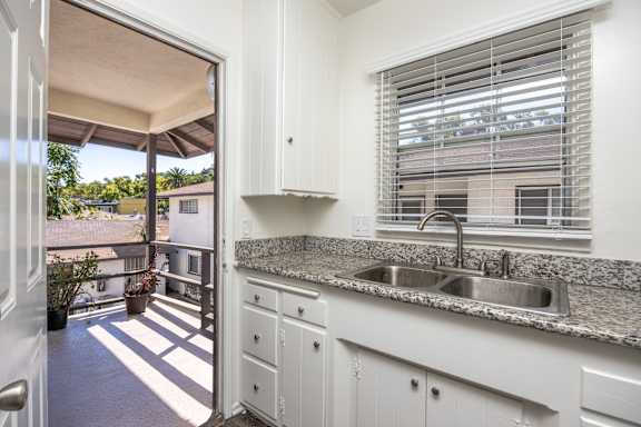 a kitchen with a sink and a window and a door to a balcony