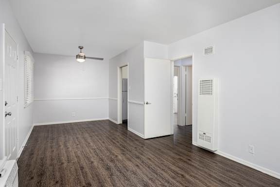 an empty living room with white walls and wood flooring