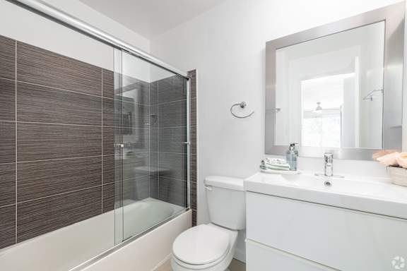A white toilet sits next to a sink in a bathroom.