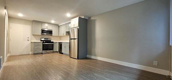 A kitchen with a refrigerator, oven, and microwave.