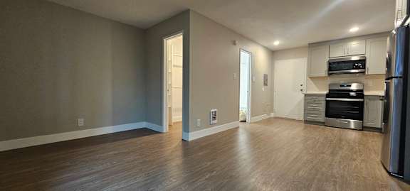 A kitchen with a refrigerator, oven, and microwave.
