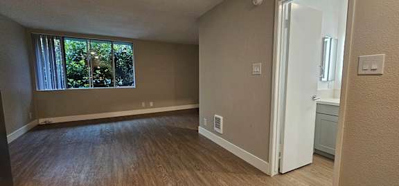 A room with a white door and a window with blinds.