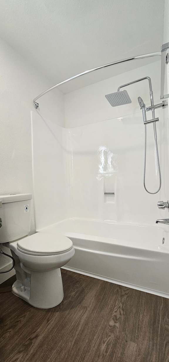 A white toilet is installed in a white bathroom.