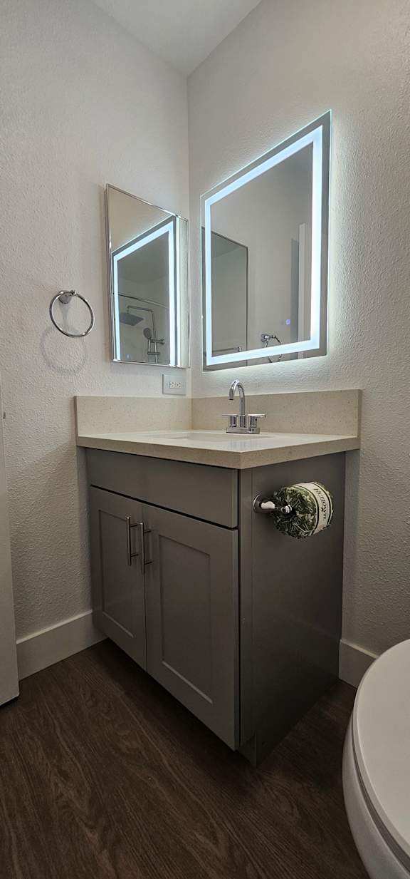 A bathroom with a toilet and a mirror above it.