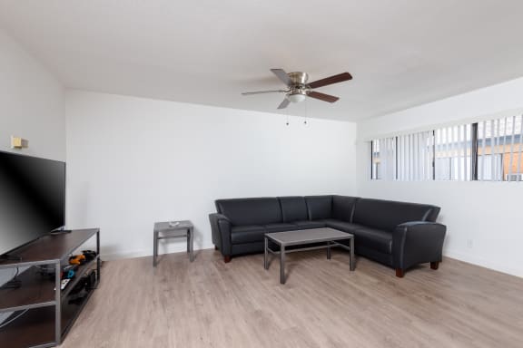 an open living room with a couch and a ceiling fan