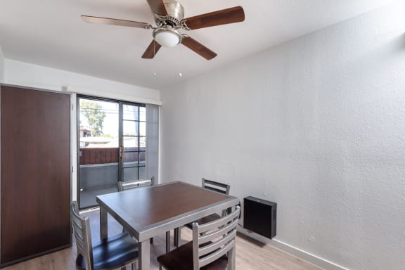 a dining room with a table and chairs and a ceiling fan