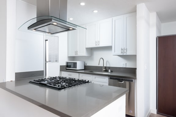 a kitchen with white cabinets and black counter tops and a stove