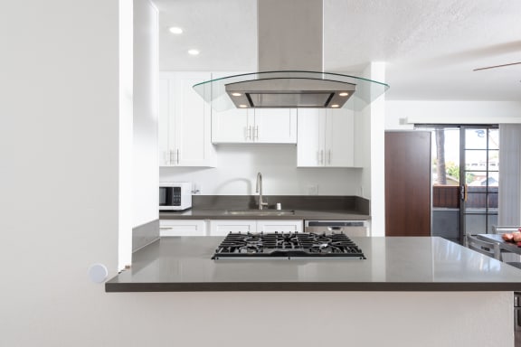 a view of a kitchen with white cabinets and a stove