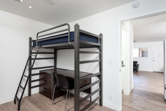 a bunk bed with a desk in a living room