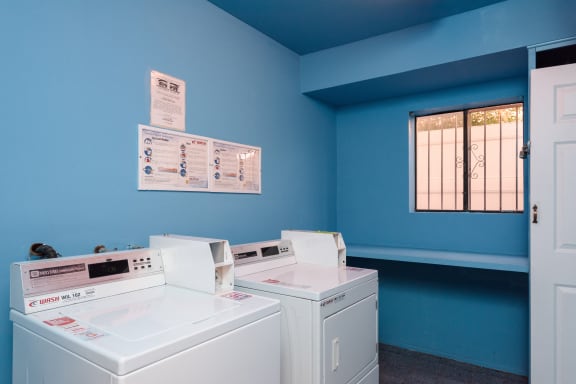 a laundry room with two washers and two washing machines