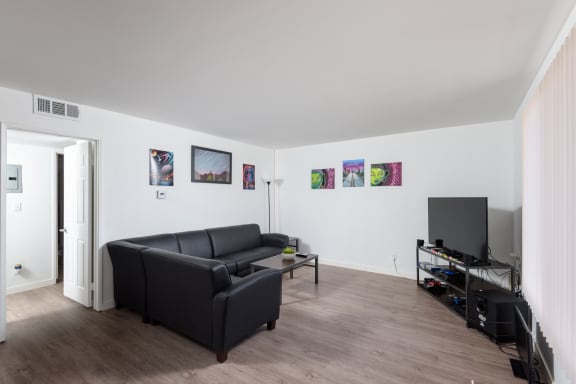 a living room with a leather couch and a tv