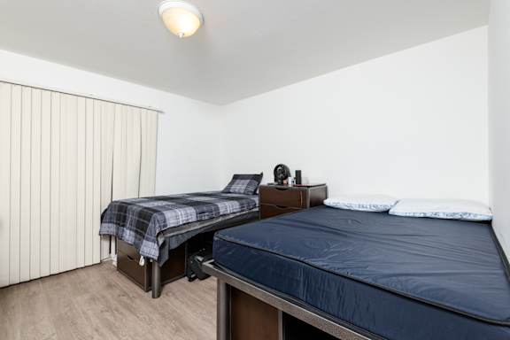 a bedroom with two beds and a large window
