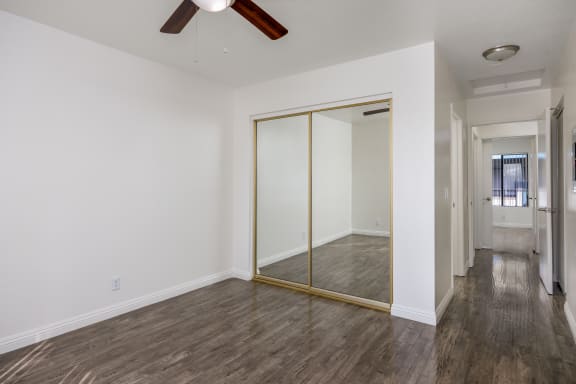 an empty room with a ceiling fan and a mirror