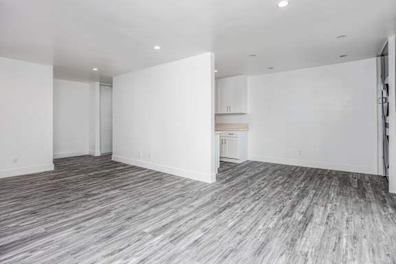 the living room and kitchen of a new home with white walls and flooring