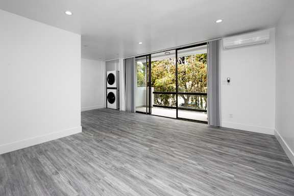 an empty living room with white walls and a window
