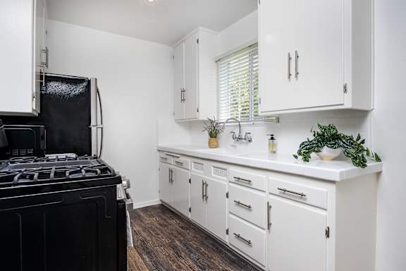 a kitchen with white cabinets and a black stove