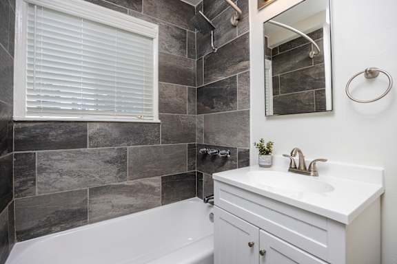 a bathroom with a sink and a tub and a mirror
