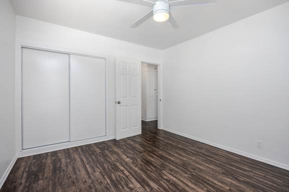an empty room with white walls and a ceiling fan