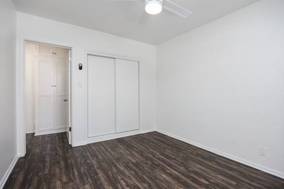 an empty living room with white walls and wood flooring
