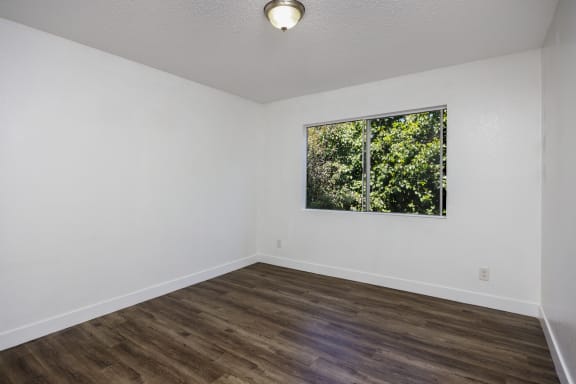 an empty room with white walls and a window