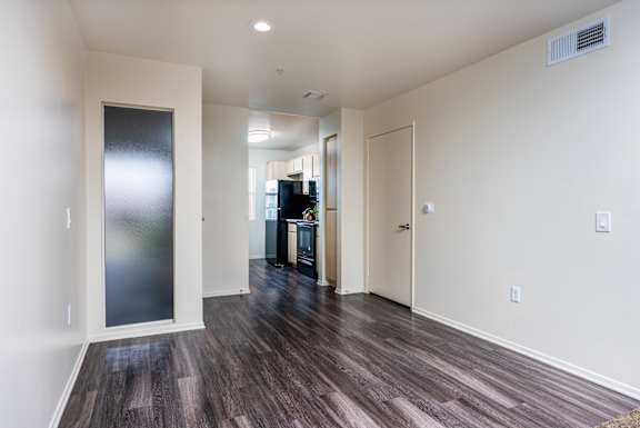 an empty living room with white walls and wood flooring