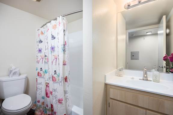 a bathroom with a shower and a sink and a toilet