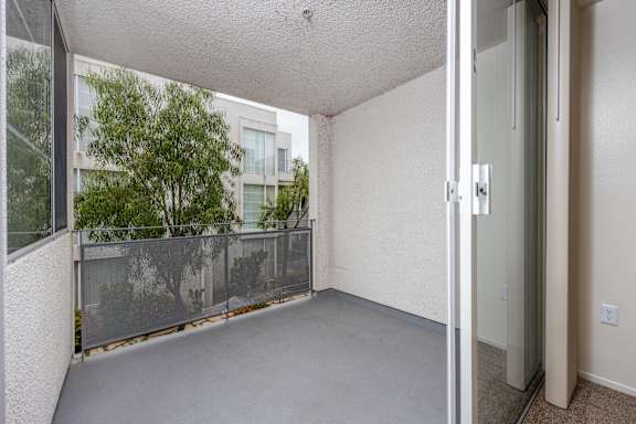 the living room of an apartment with a balcony