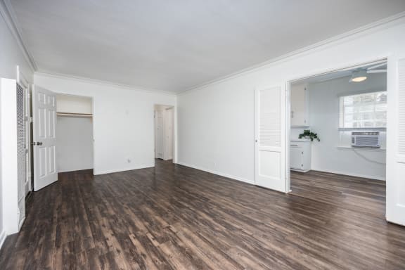 an empty living room with white walls and wood floors