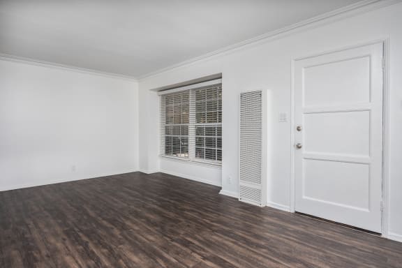 an empty living room with a window and a door