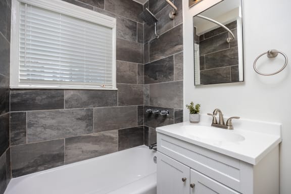 a bathroom with a sink and a tub and a mirror